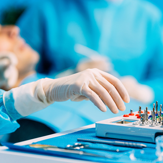 Hand reaching for tray of dental tools