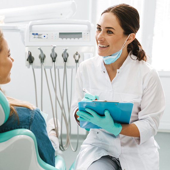 Dentist taking notes while talking with patient
